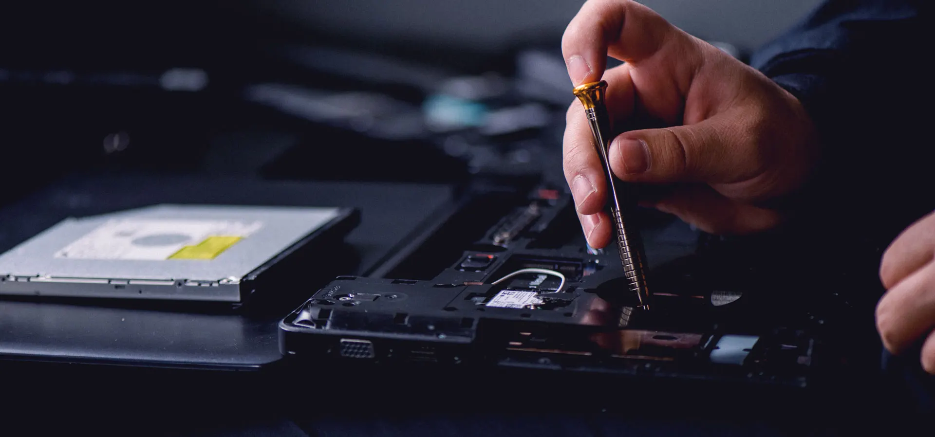 Technician repairing a hard drive with a precision tool